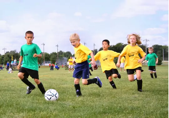 A group of children playing soccer.