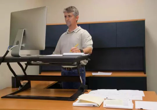 A man working on a standing desk.