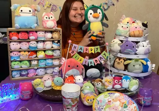 A woman holding Squishmallows.