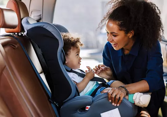 A baby placed in a car seat for safety.