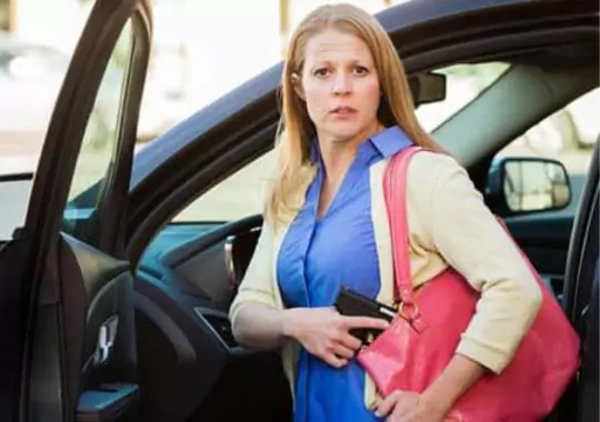 A woman carrying a concealed carry purse.