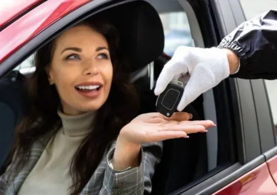 A woman receiving a car key fob.