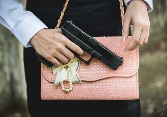 A Woman with a handgun purse.