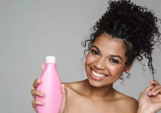 A woman with a bottle of shampoo.