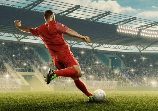 A Soccer player kicks a ball.